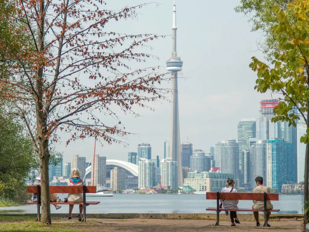 Toronto skyline seen across the water from a leafy park